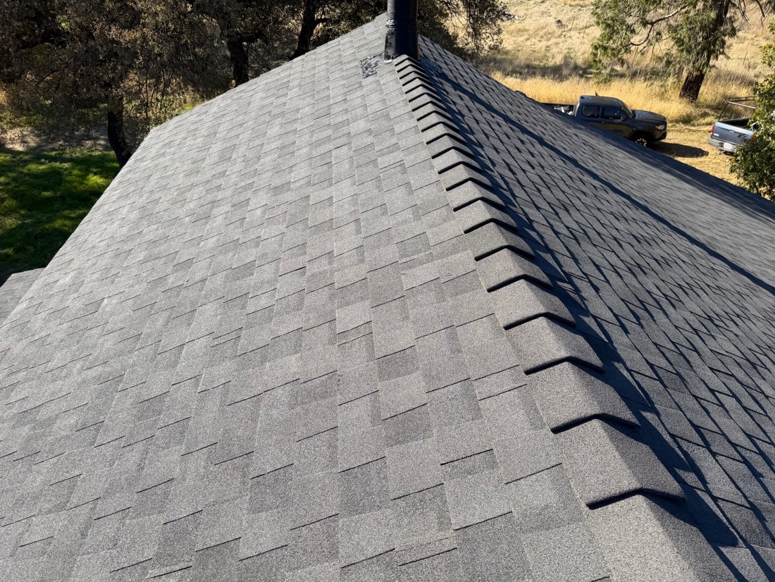 Charcoal architectural shingles along a ridge
