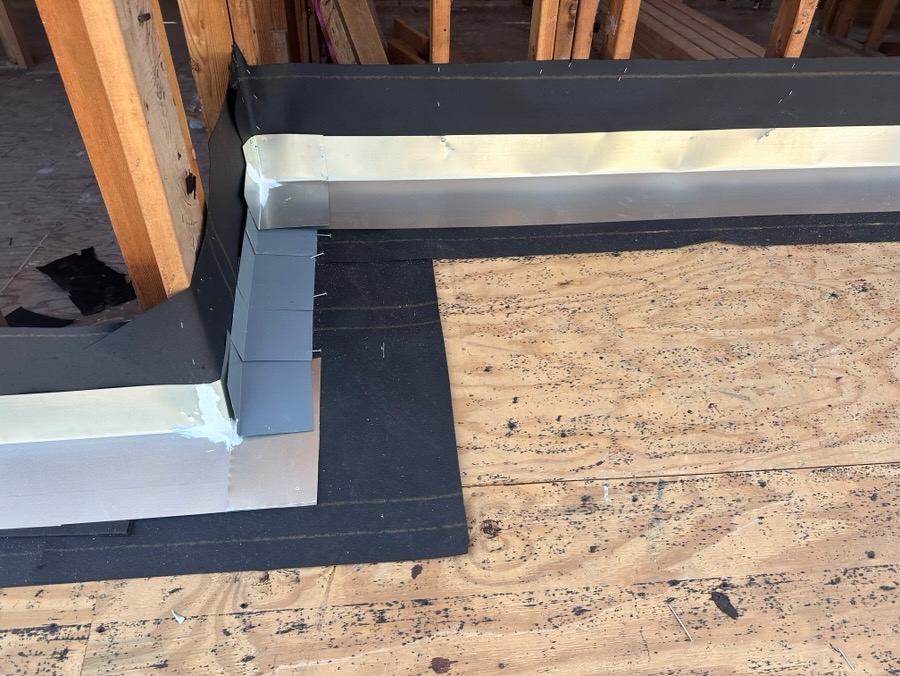 Flashing detail where a low-slope roof meets a wall